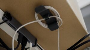 Sauber aufgewickeltes Kabel in einer Kabelhalterung unter dem Schreibtisch